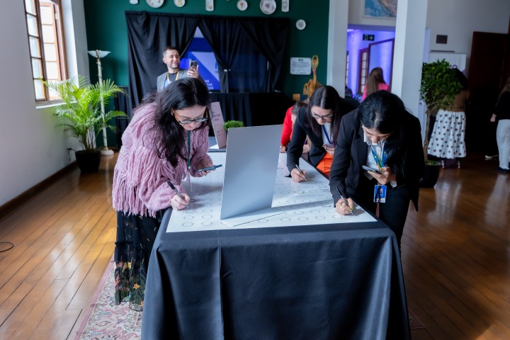 Participantes assinando mural de atividades no NEXO 2026