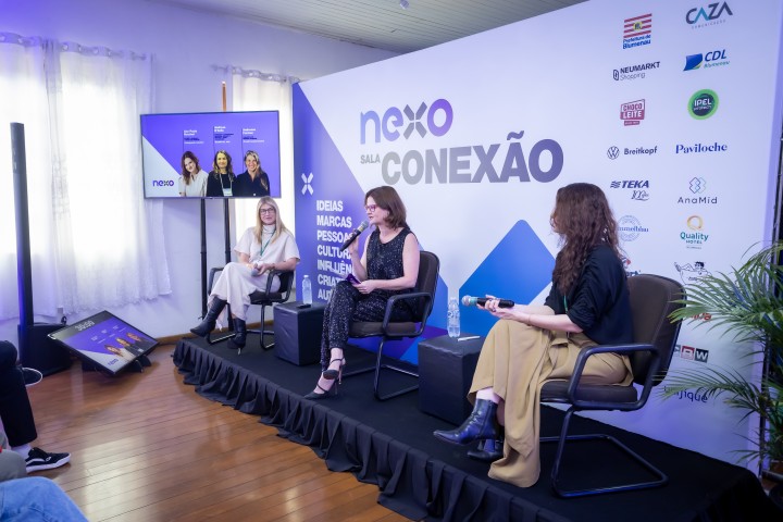 Painel Sala Conexão com três mulheres no palco