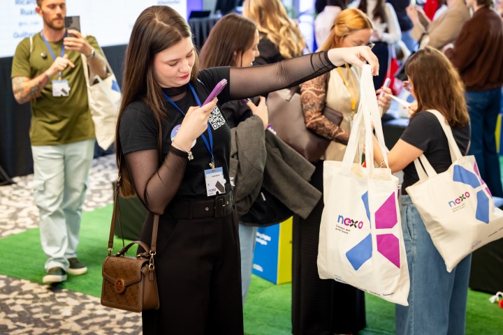 Participante com tote bag NEXO na área de networking