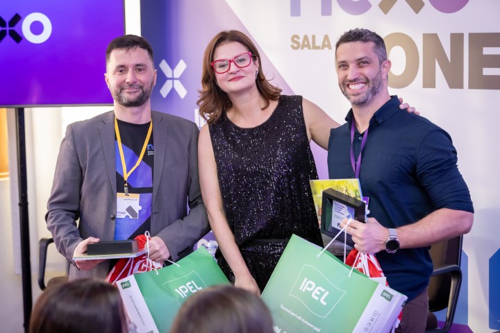 Três participantes com gift bags no NEXO 2026