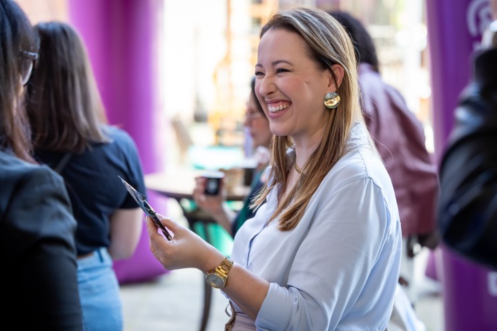 Participante sorrindo durante networking no NEXO 2026