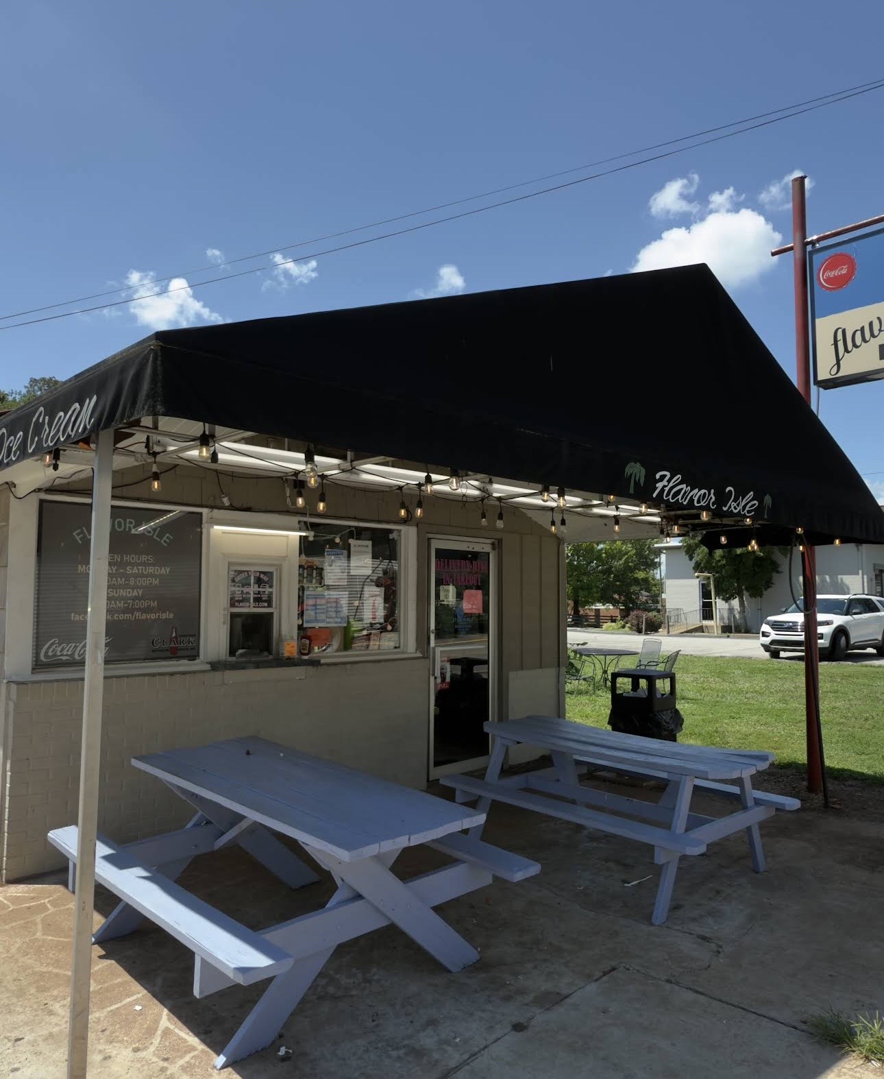 Walk-up window and blue picnic tables under the awning