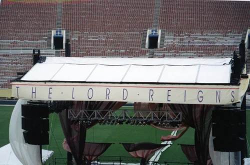 'The Lord Reigns' banner atop the stage