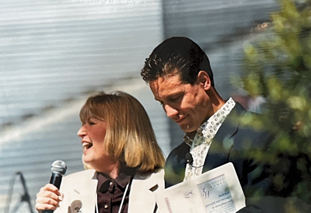 Susan Kimes and co-host on stage with program