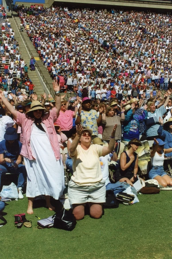 Women kneeling in worship on the field
