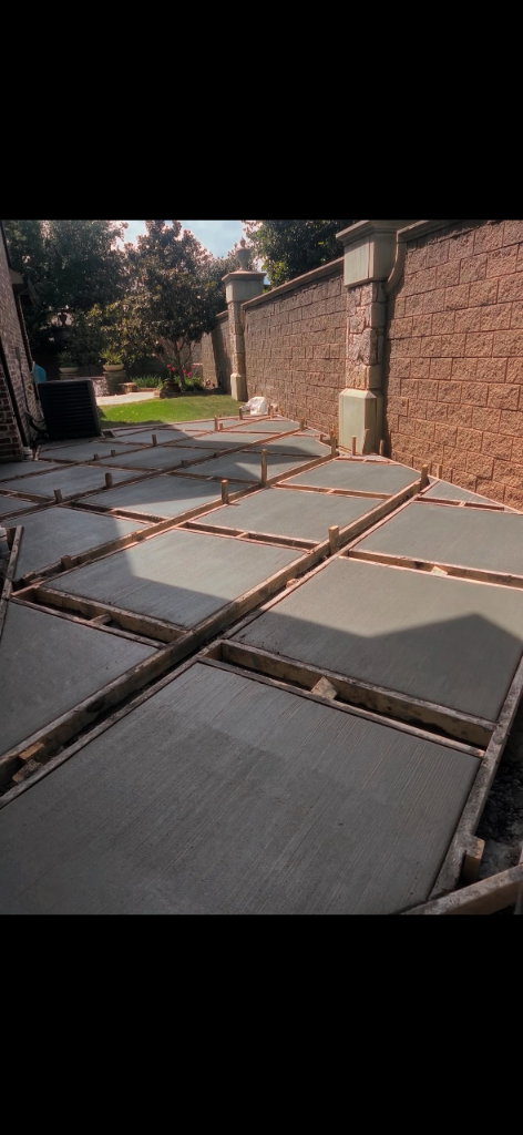 Grid of wooden formwork staked out over prepared ground before a concrete pour
