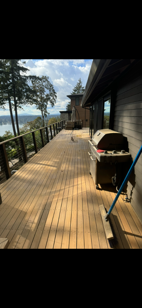 Large elevated deck near completion with cable railing overlooking a lake