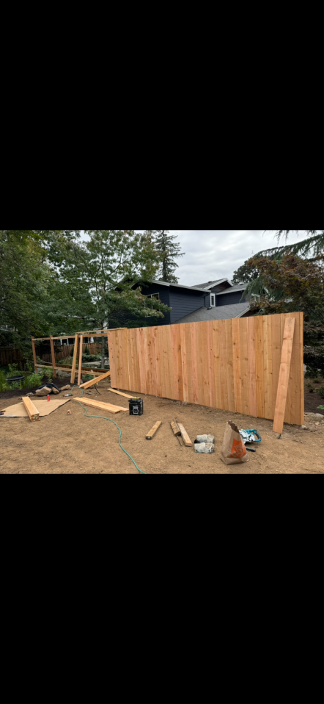 Cedar privacy fence pickets being installed with framing still exposed