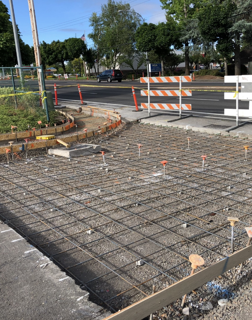 Burnt-orange stamped flagstone concrete sidewalk with smooth grey border curbs