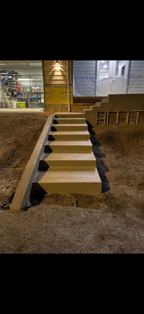 Freshly poured concrete entry steps finished in low evening light
