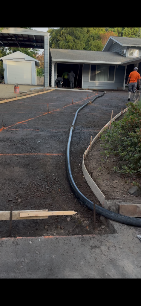 Gravel base with orange string lines and wooden formwork laid out for a concrete pour