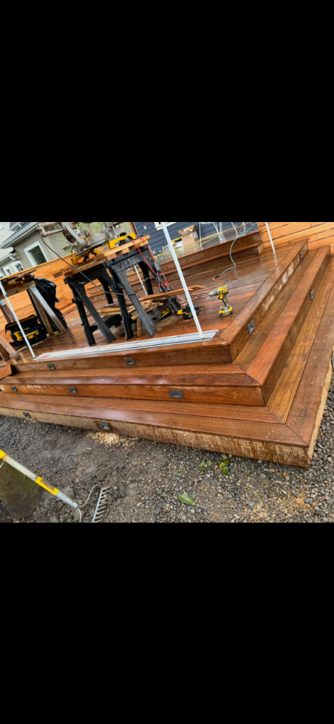 Multi-tiered wooden deck under construction with recessed riser lights