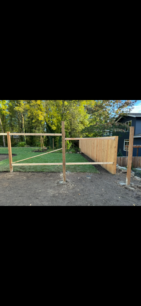 Fence framing with posts and rails braced, partial pickets attached