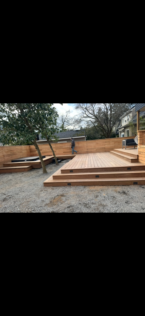 Completed multi-level deck with hot tub, staircase and horizontal slat fence