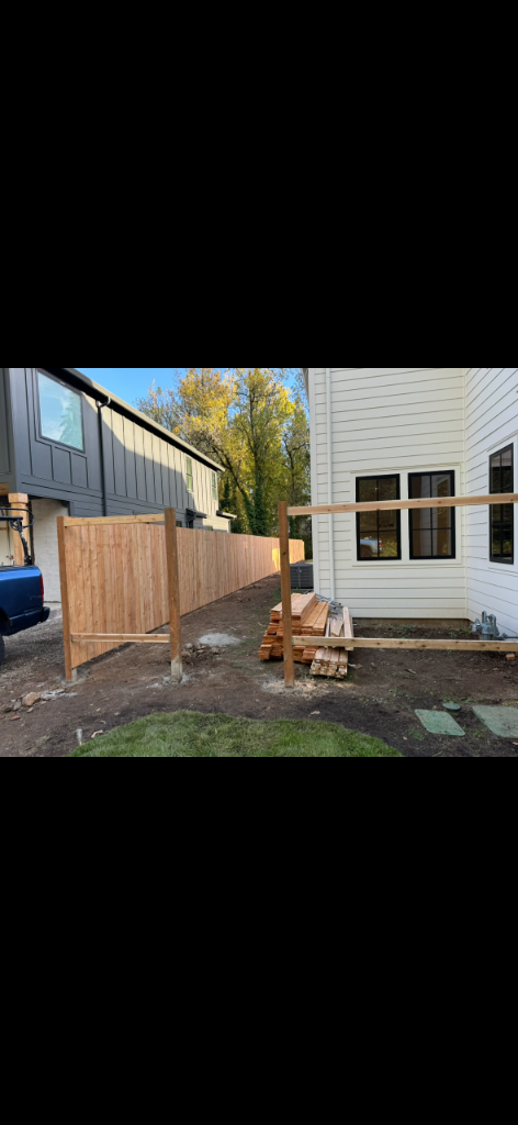 Fence posts set in concrete footings with horizontal rails between them