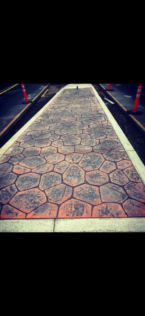 Completed stamped concrete walkway with flagstone pattern and smooth border