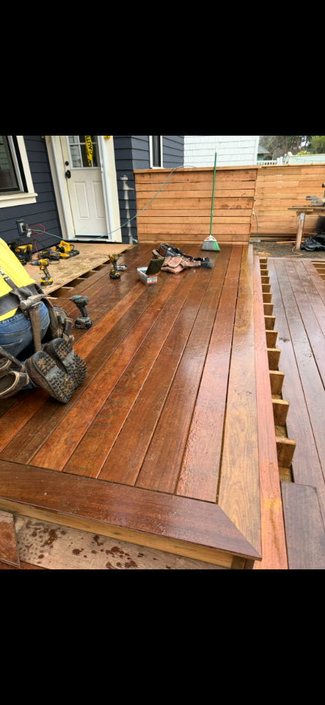 Worker installing deck planks with drills and screws