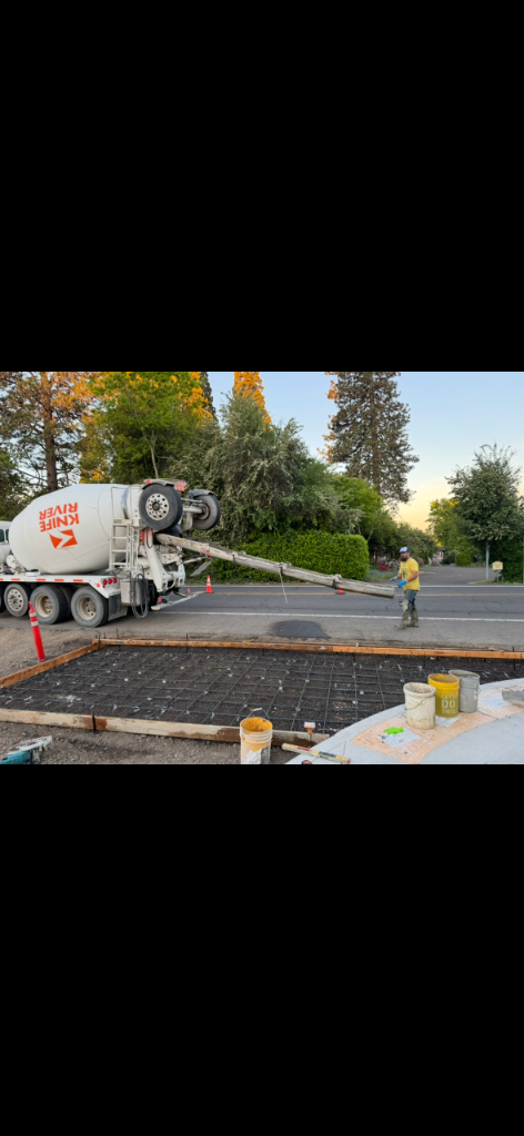 Wire mesh reinforcement laid in formwork beside a concrete mixer truck on site