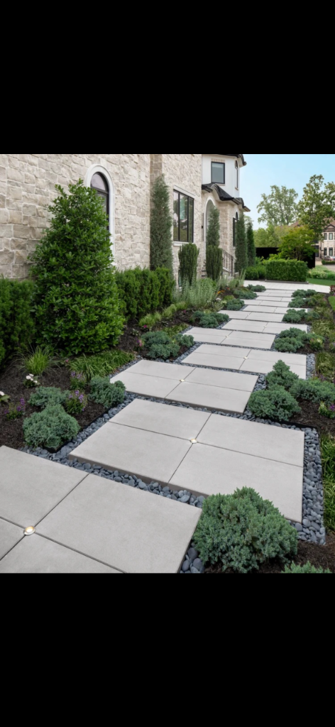 Finished pathway of large square concrete pavers with integrated center lights and river-stone joints