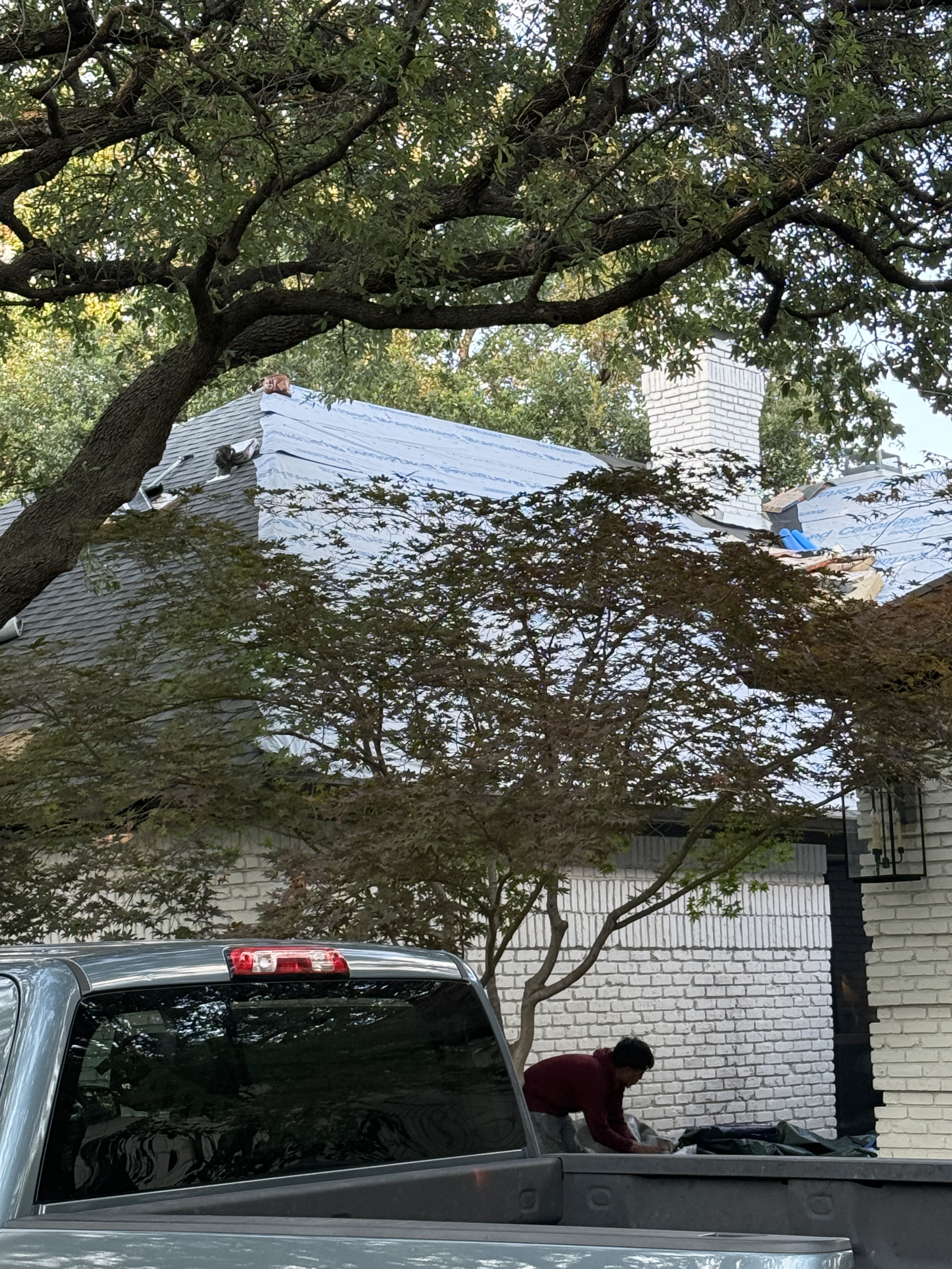 Roof Pros Dallas crew working beside a residential roof during a replacement project
