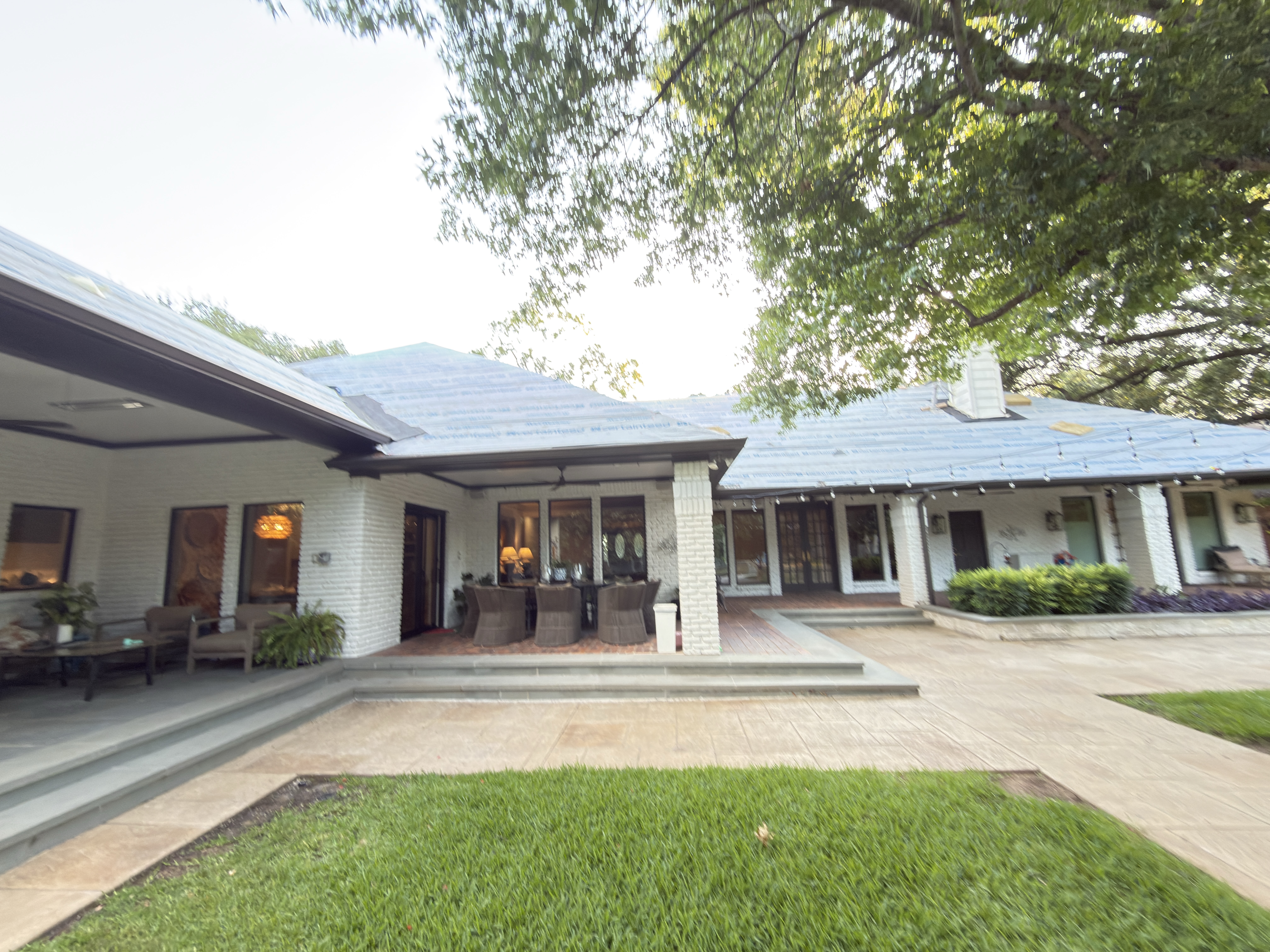 Rear of a DFW home mid-re-roof with synthetic underlayment installed by Roof Pros Dallas