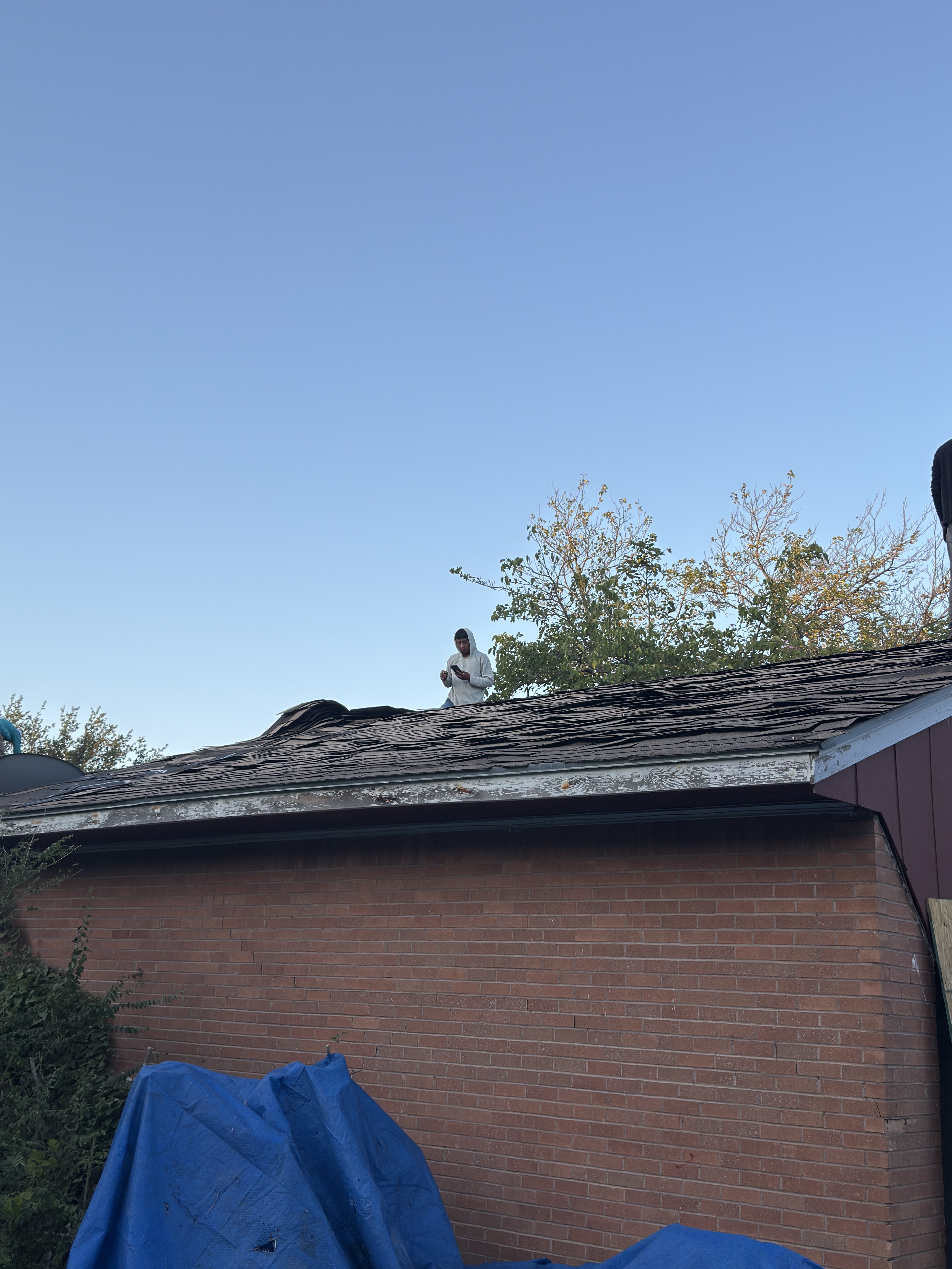 Roof Pros Dallas crew member on a pitched roof during a residential replacement