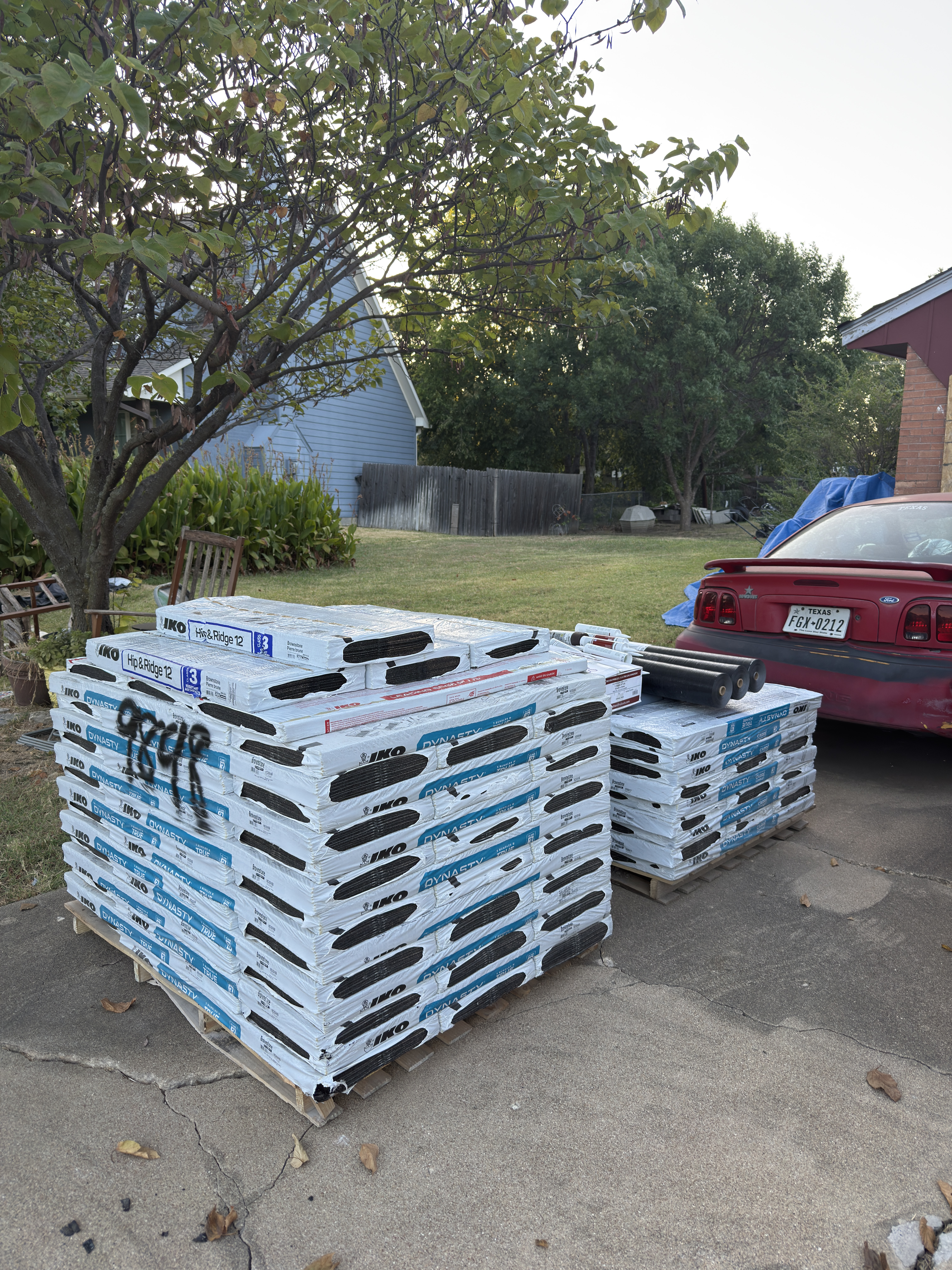 Roofing shingle and underlayment delivery staged on a DFW driveway by Roof Pros Dallas