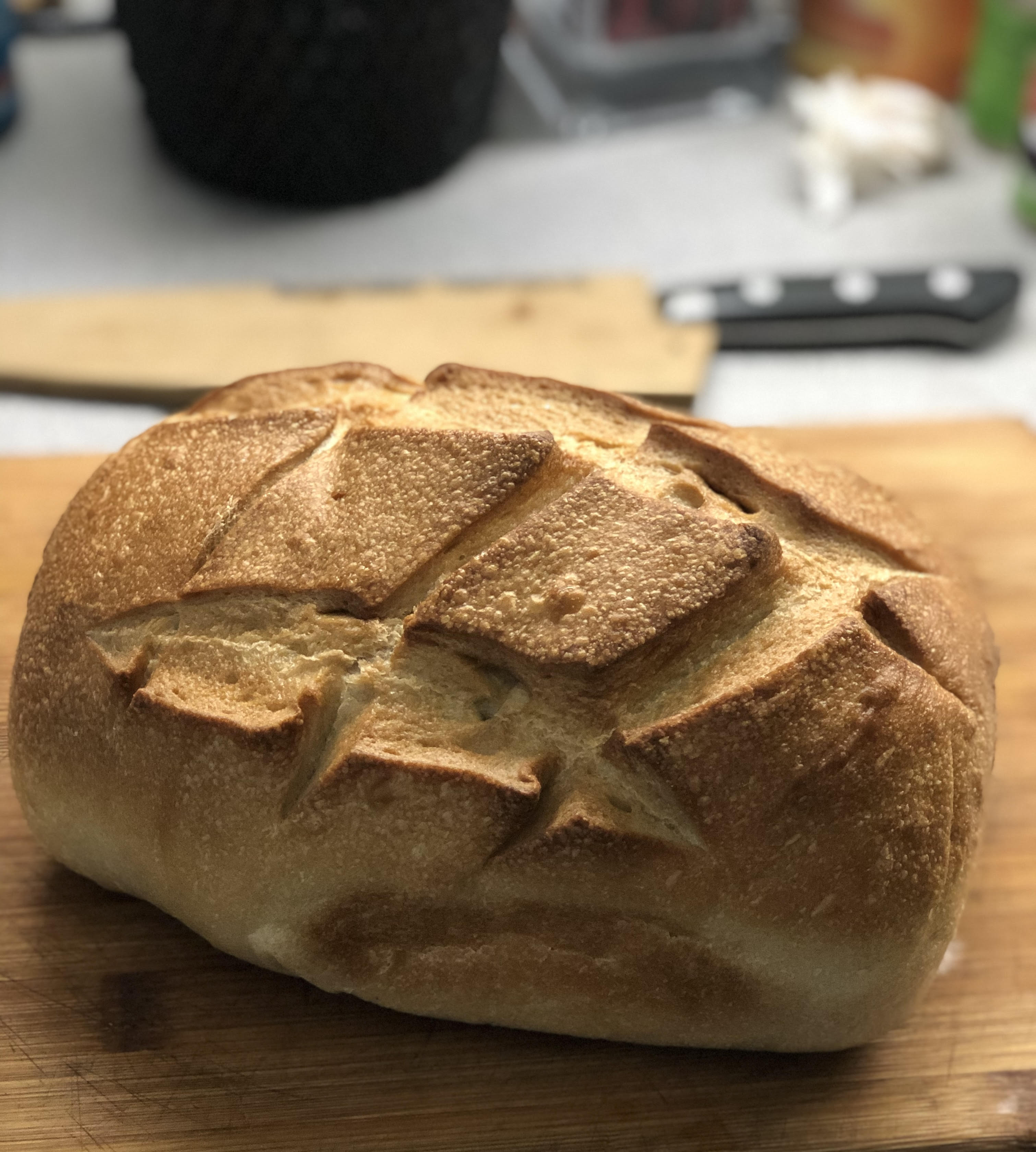 Freshly baked sourdough loaf on a wooden cutting board