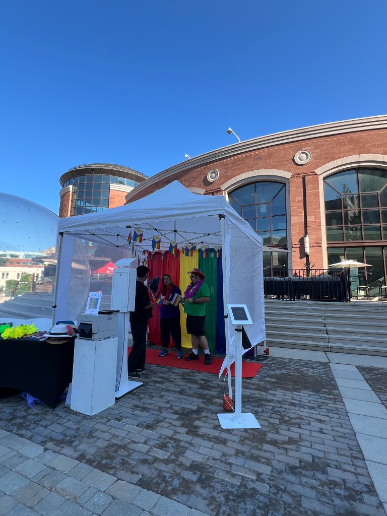 Wide shot of IMAGICA bubble dome and photo booth tent setup at Brampton Pride outdoor event