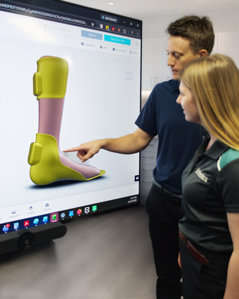 An iOrthotics podiatrist and a partner practitioner reviewing a 3D foot scan together