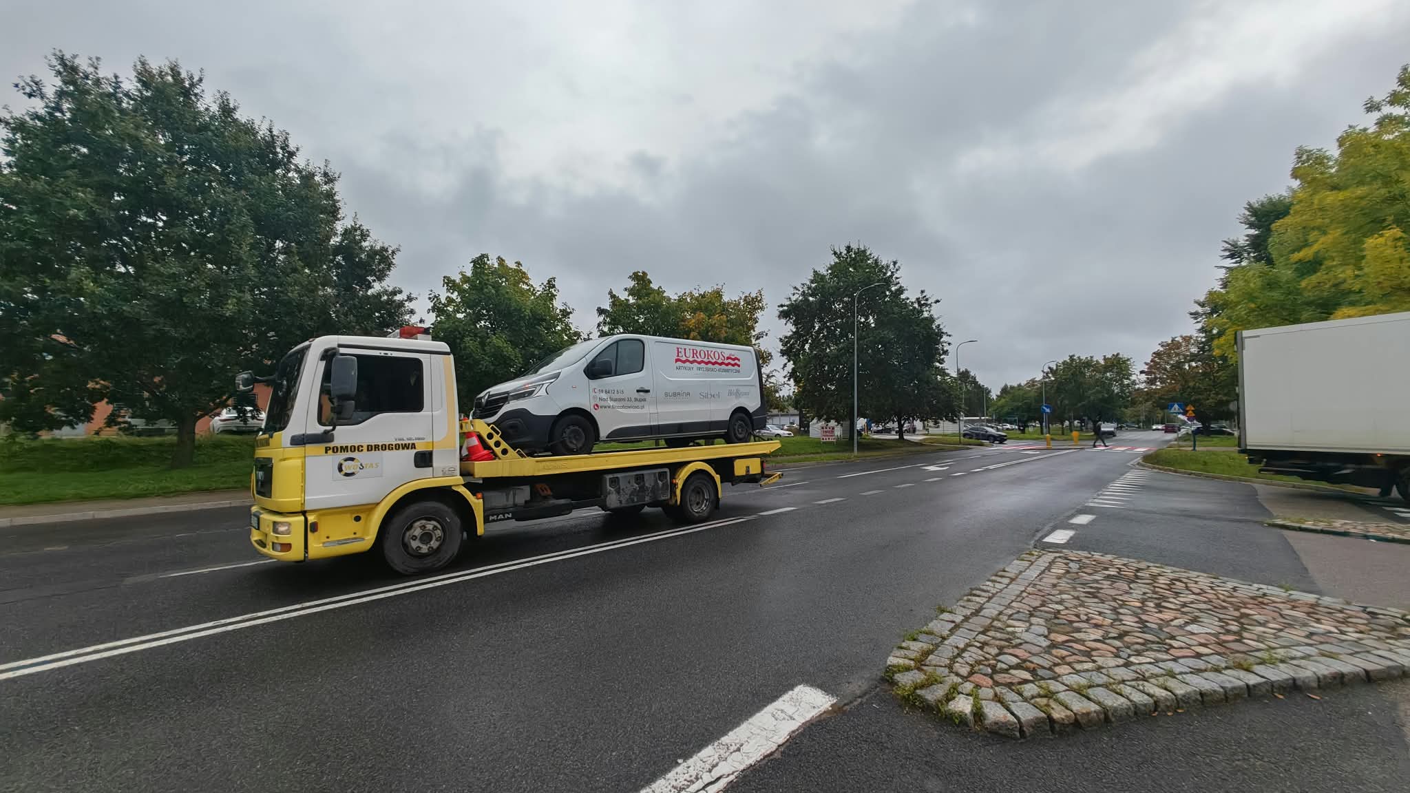Transport samochodu dostawczego żółtą lawetą w Słupsku