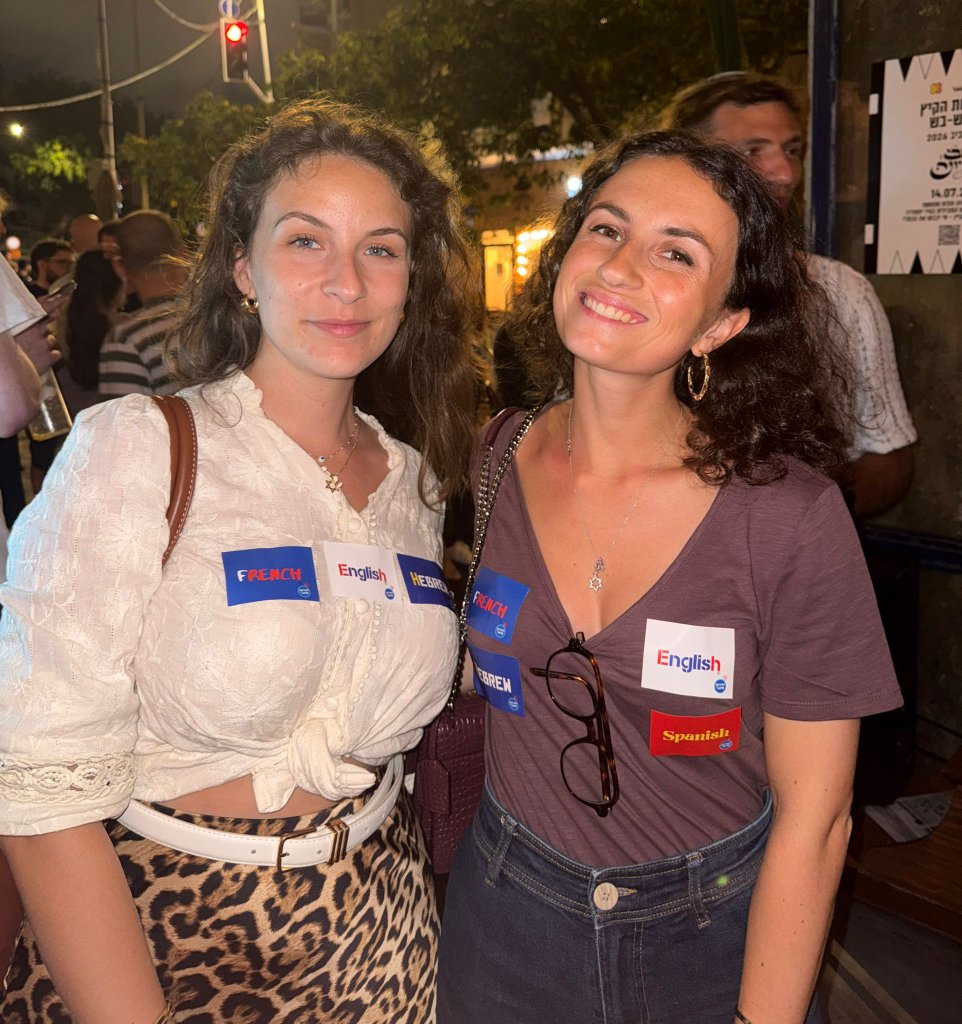 Two women with language stickers outside the bar