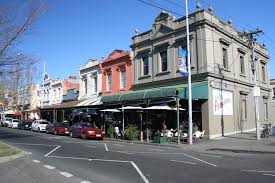 Carlton's Lygon Street at night — warm light from Italian restaurants spills onto the pavement