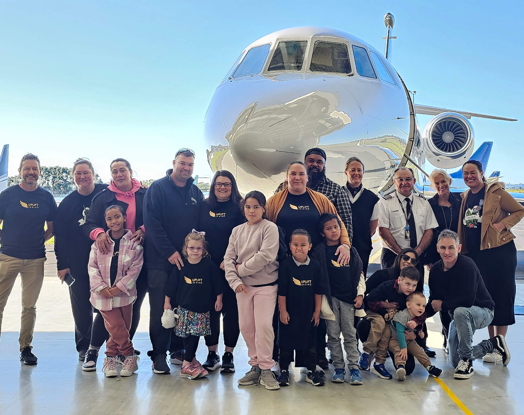 Uplift in Kind community group in front of a private jet