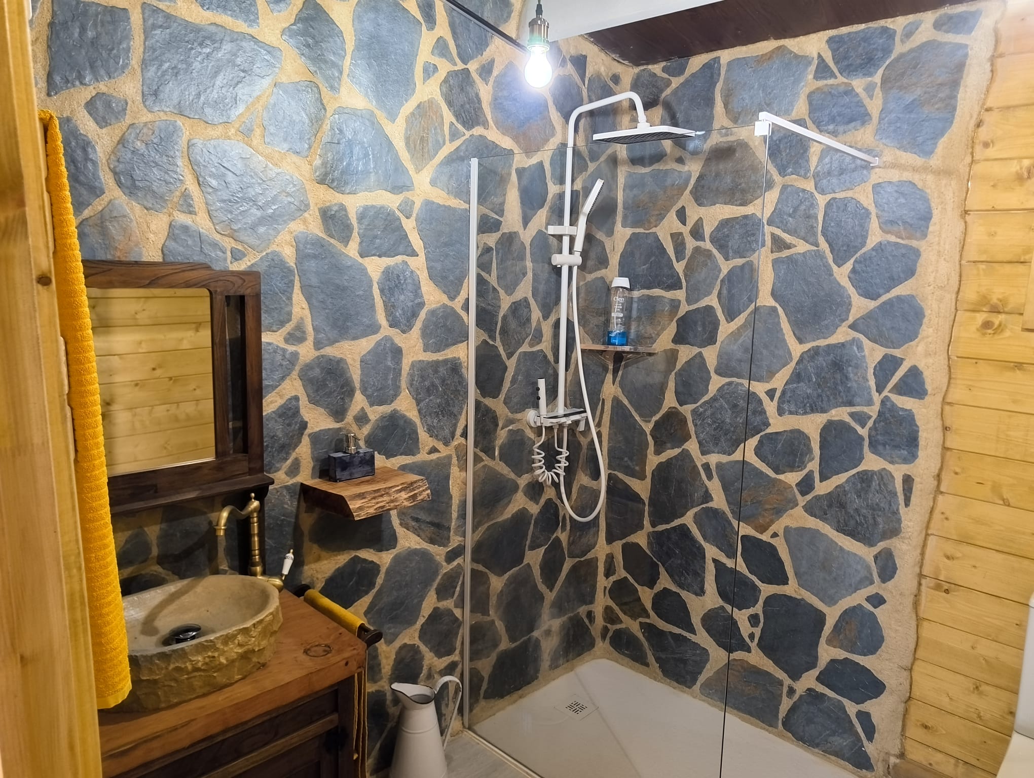Baño con piedra natural en casa de madera