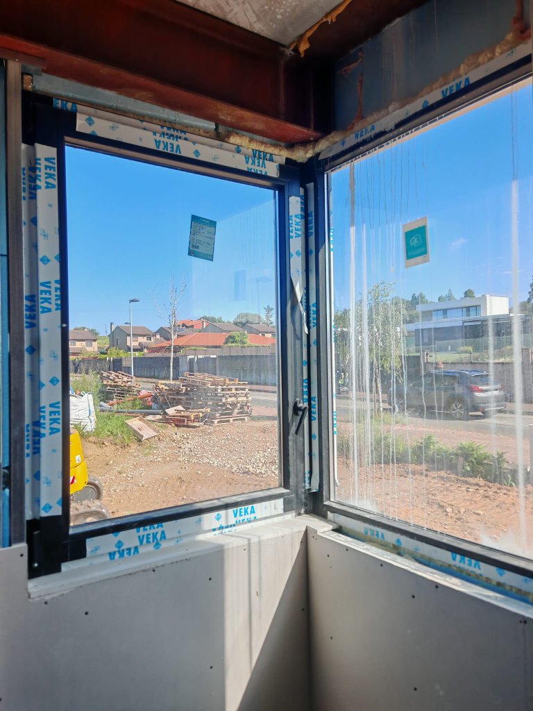 Ventana de esquina con perfiles de aluminio negro en fase de instalación