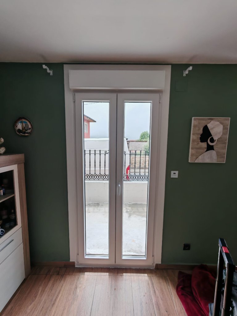 Ventana doble de PVC en pared verde