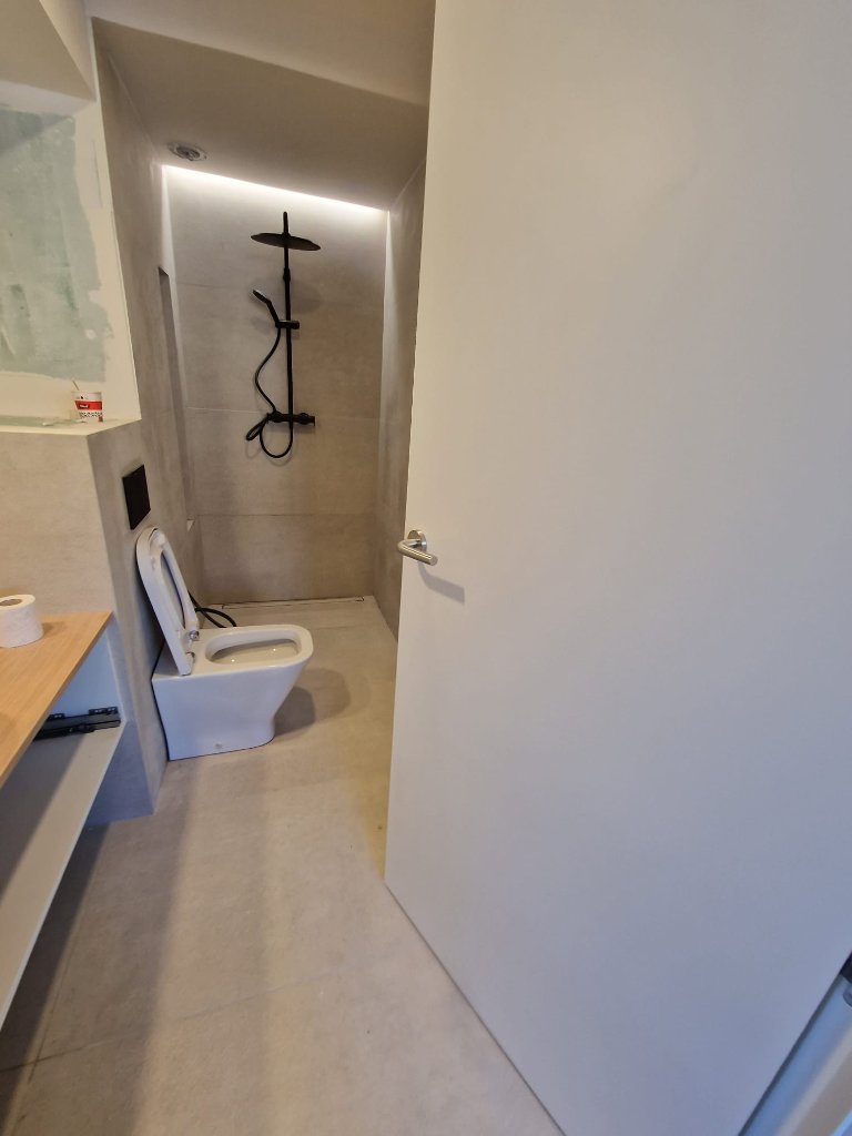Baño con microcemento y ducha negra