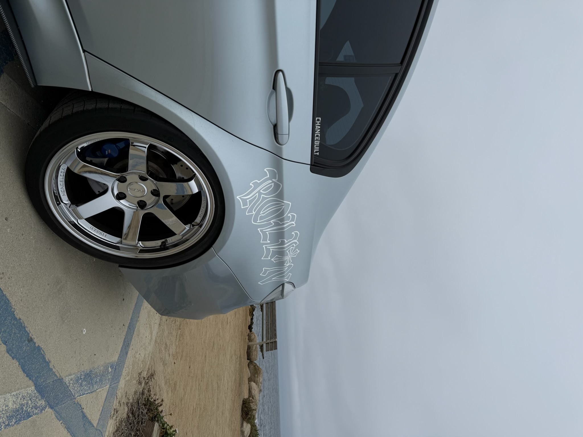 ROLLIN Signature Banner decal on a silver car by the coast