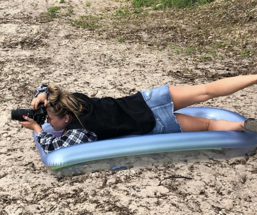 Taylor taking photos while lying on an inflatable pool float