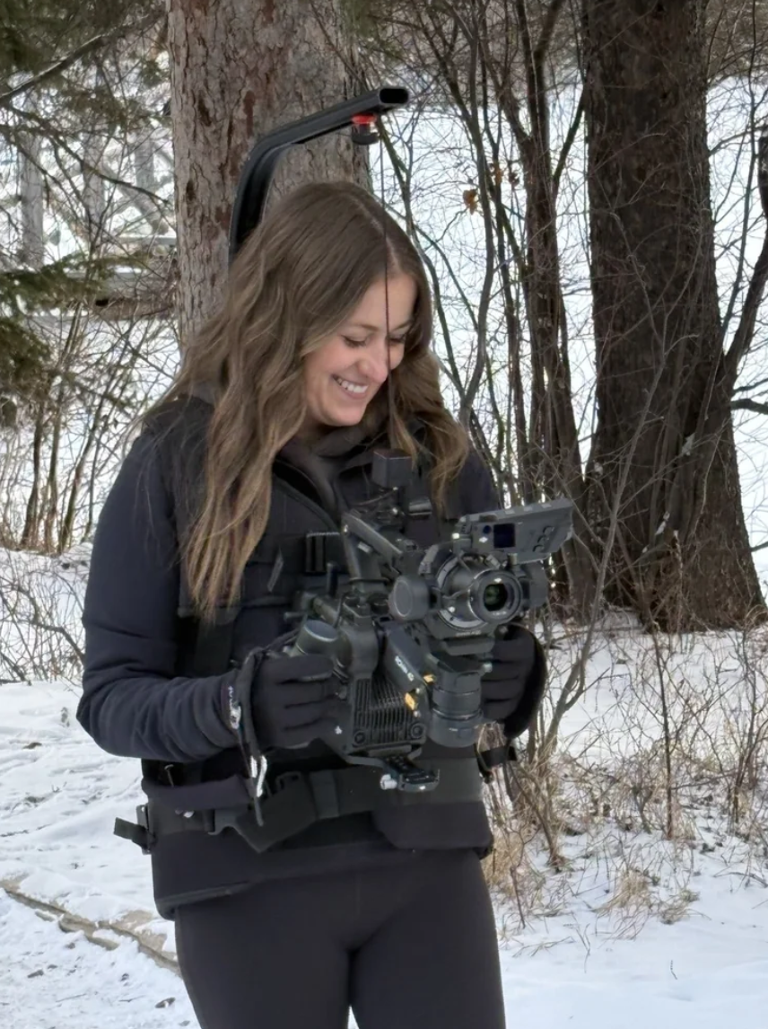 Taylor smiling with her cinema camera rig in the snow