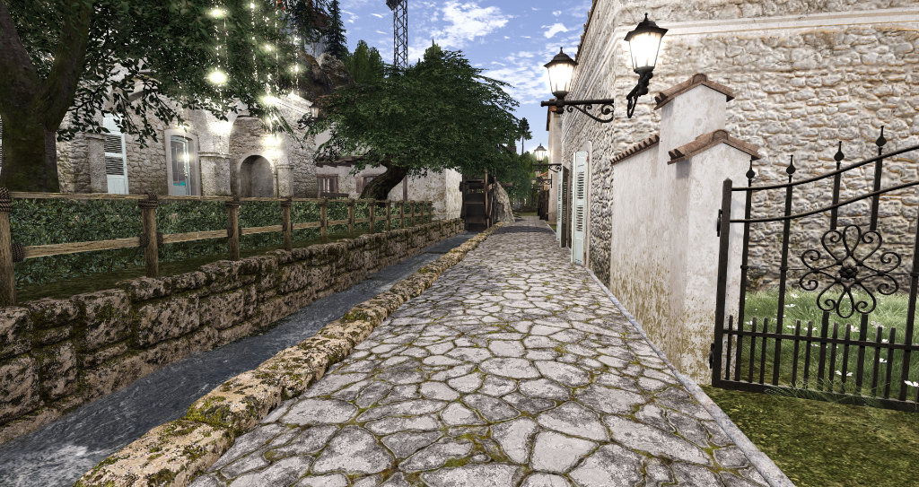 Cobblestone alley with stone walls and iron gate