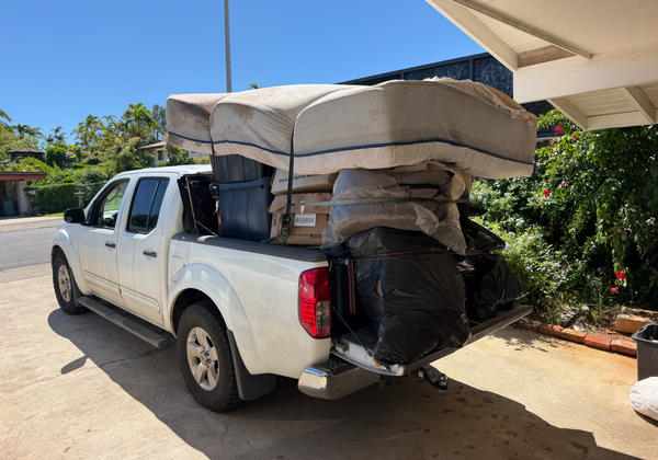 White pickup truck loaded with junk from a Kahala cleanout — load 2