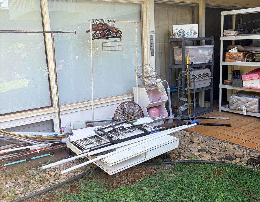 Junk piled on a Kahala patio before removal — view 2