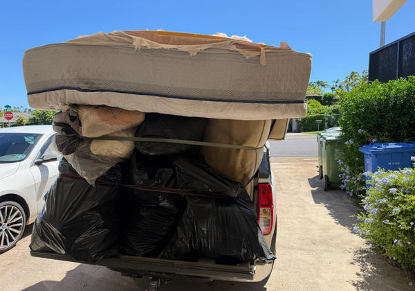 White pickup truck loaded with junk from a Kahala cleanout — load 1