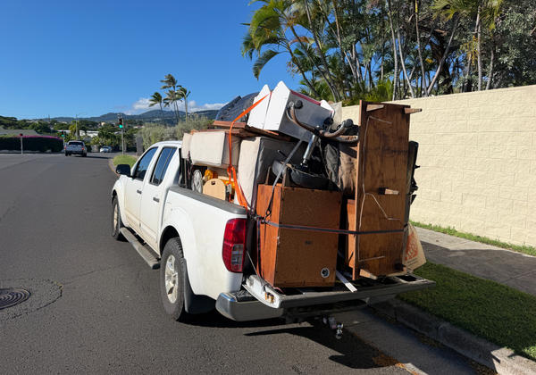 White pickup truck loaded with junk from a Kahala cleanout — load 3