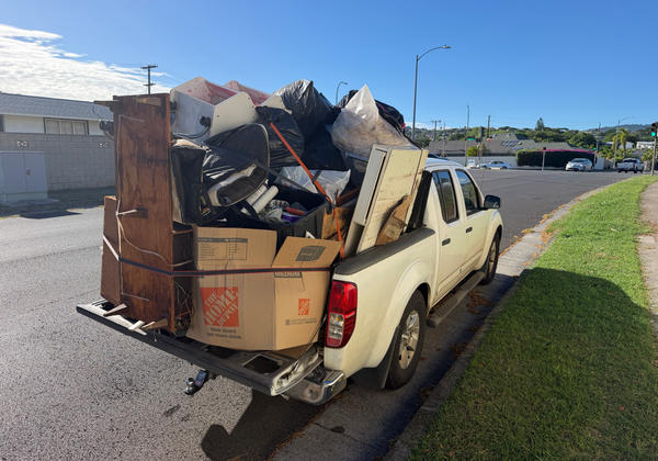 White pickup truck loaded with junk from a Kahala cleanout — load 4