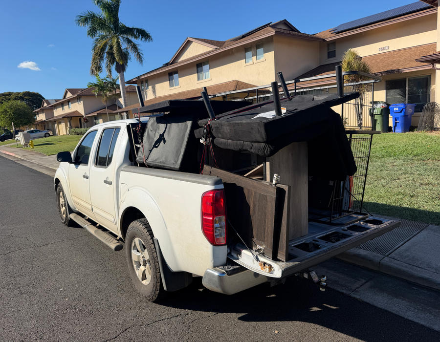 White pickup truck loaded with furniture from a Pearl Harbor cleanout