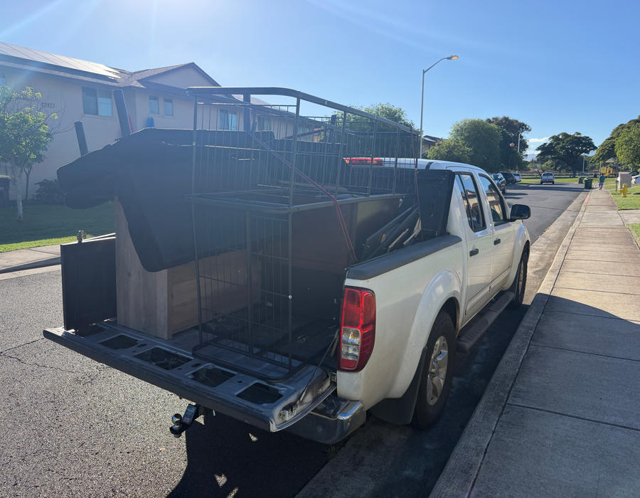 White pickup truck loaded with junk from a Pearl Harbor cleanout, rear view