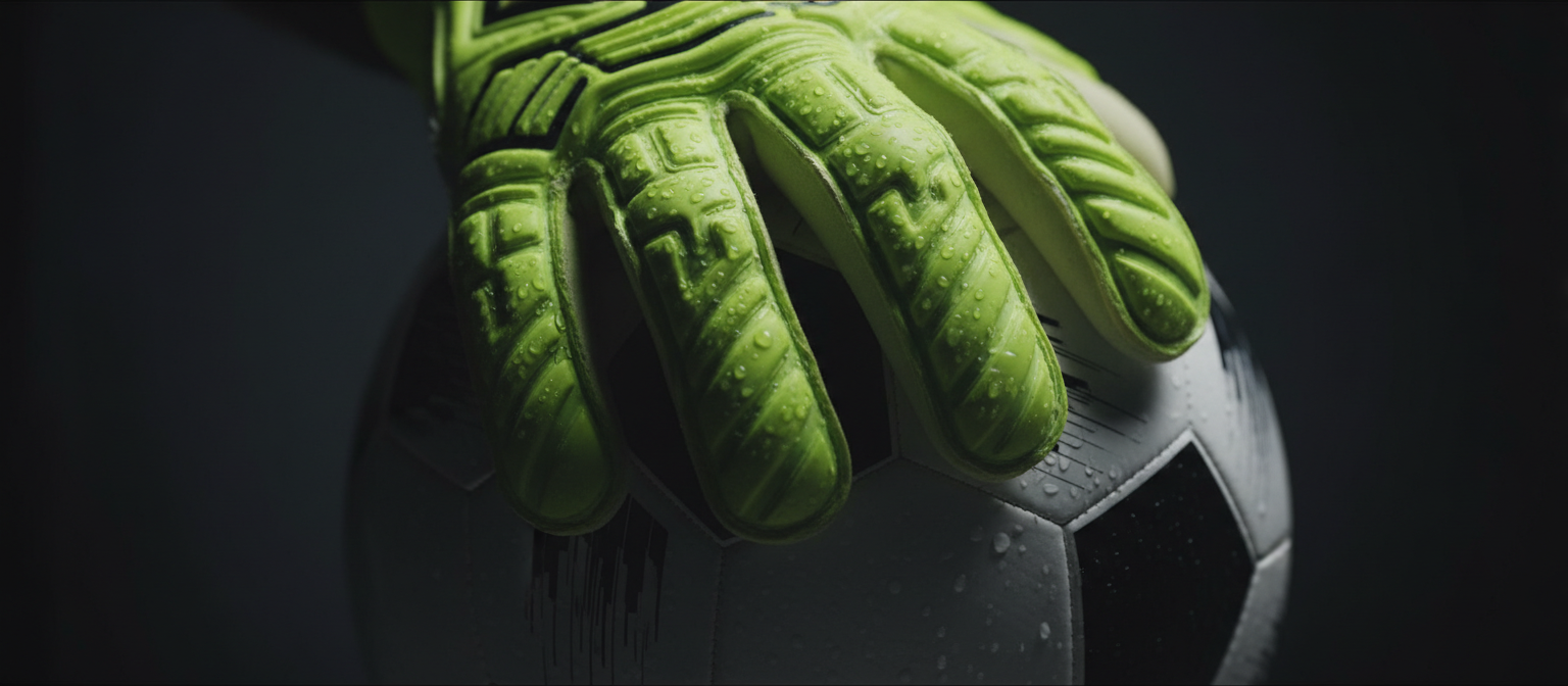 Goalkeeper gloves gripping a ball